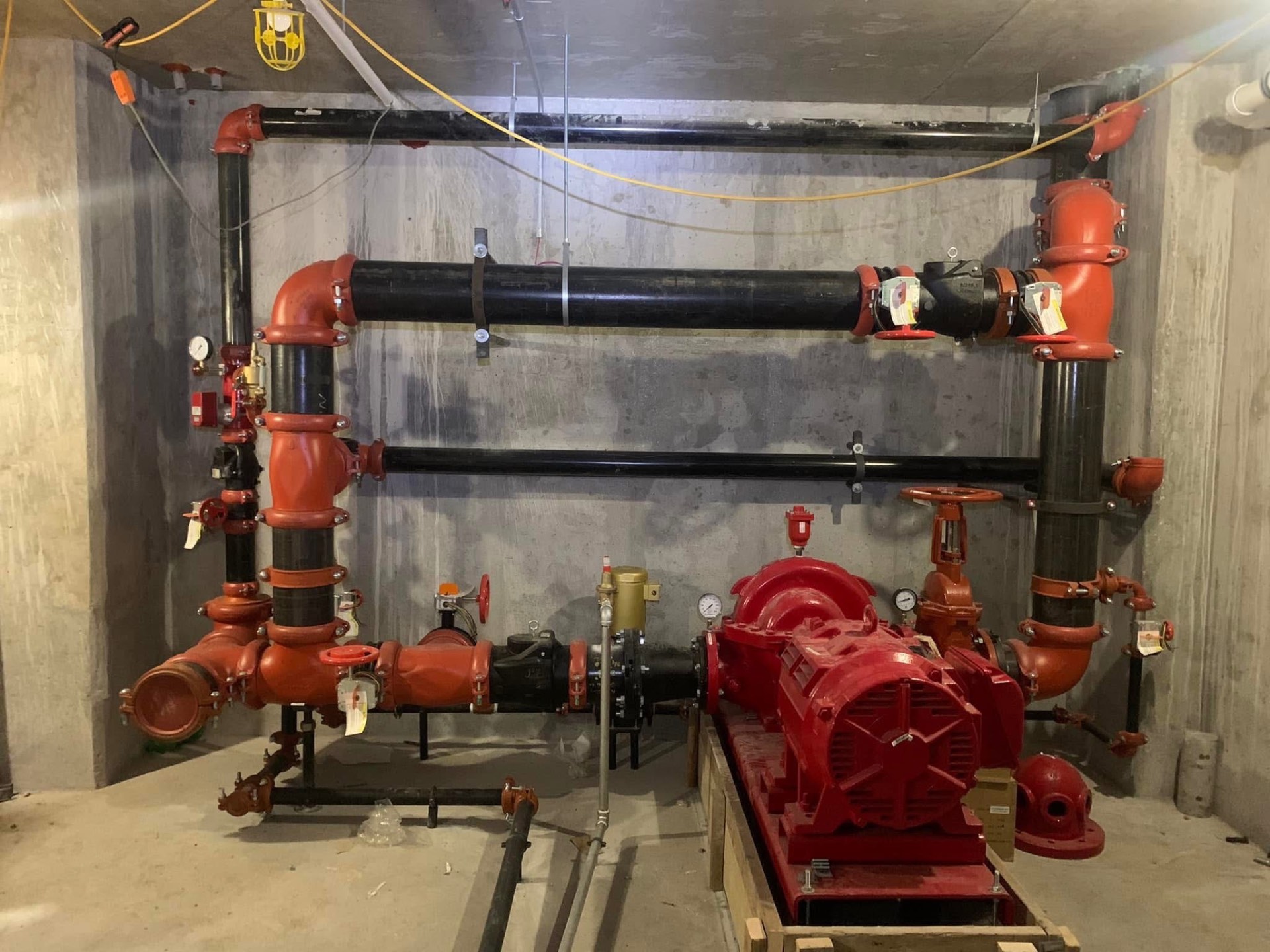 Fire pump room with grooved black steel piping and electric driver